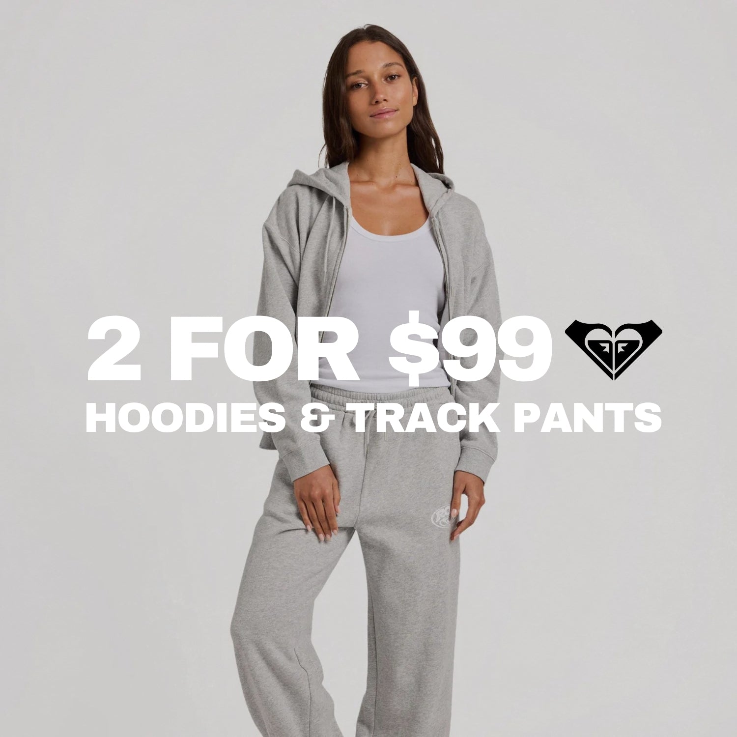 A woman modeling a light gray zip-up hoodie and matching gray track pants against a light gray studio background, with large overlaid text reading '2 FOR $99 HOODIES & TRACK PANTS' and a black heart logo.