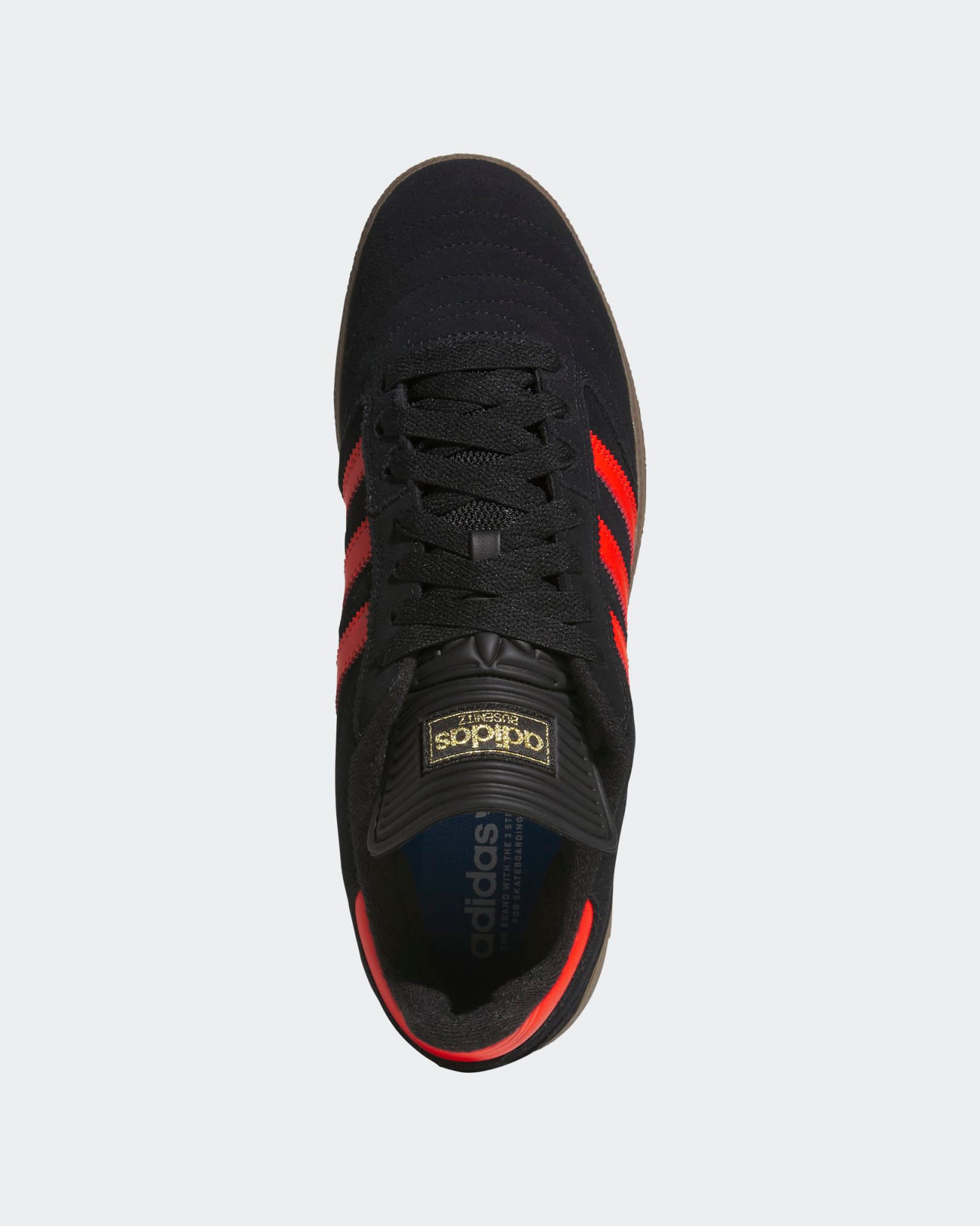Top view of black Adidas sneakers featuring vibrant red stripes, gold tongue branding, and a sleek, low-profile design.