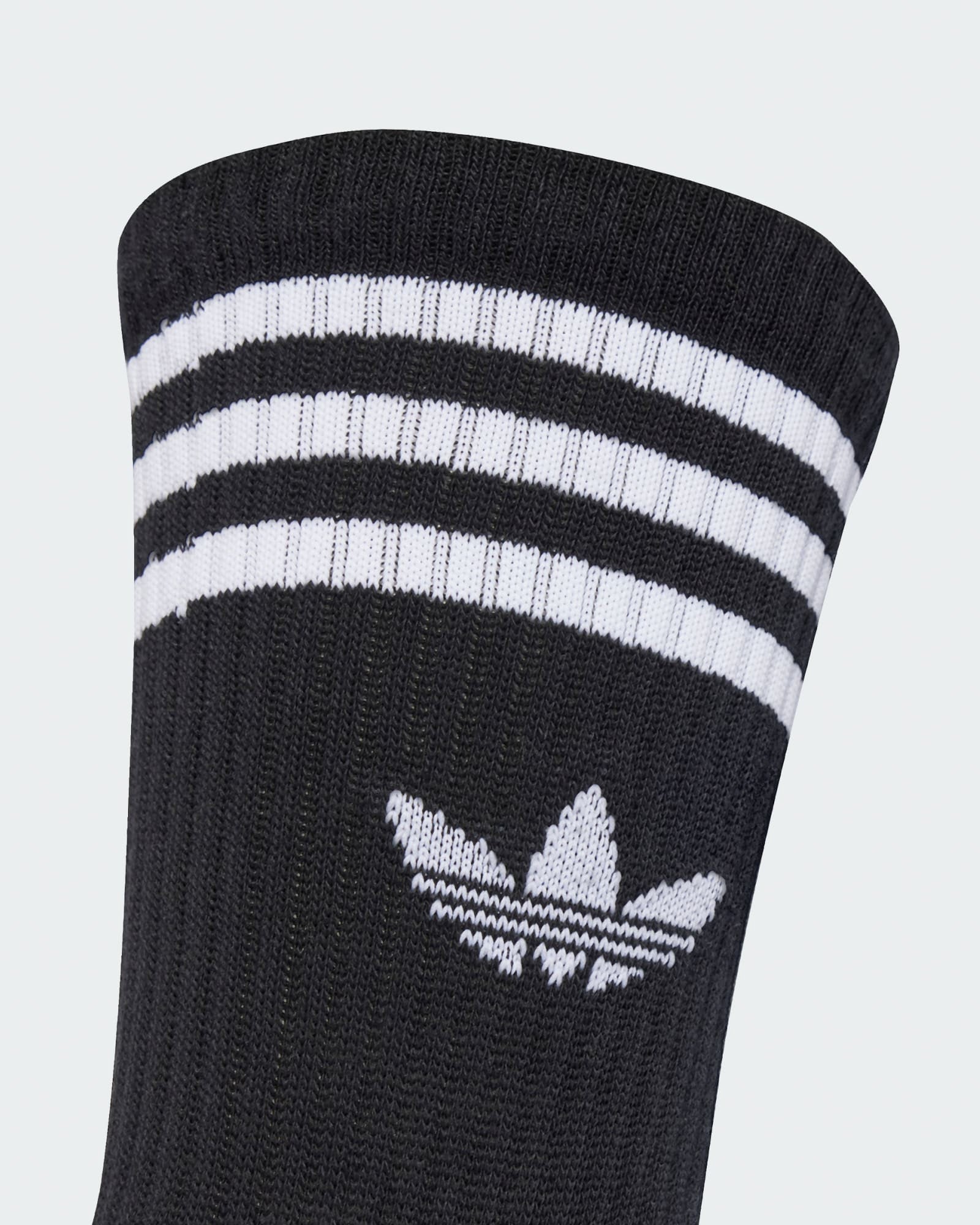 Detail of adidas crew sock cuff with white trefoil logo and triple stripe design for a classic sporty look.