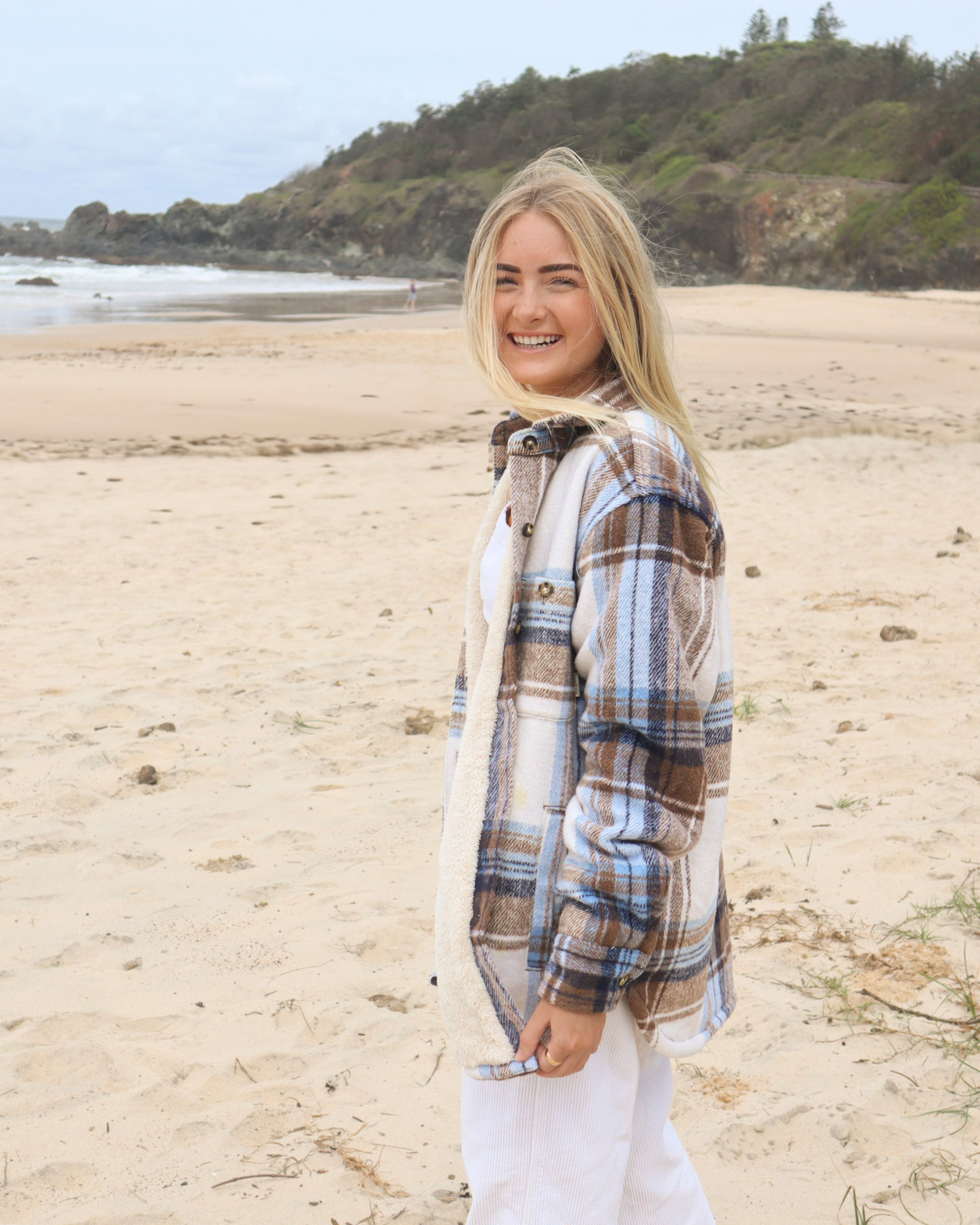 Side view of oversized cream and brown check shacket with button detail, worn open