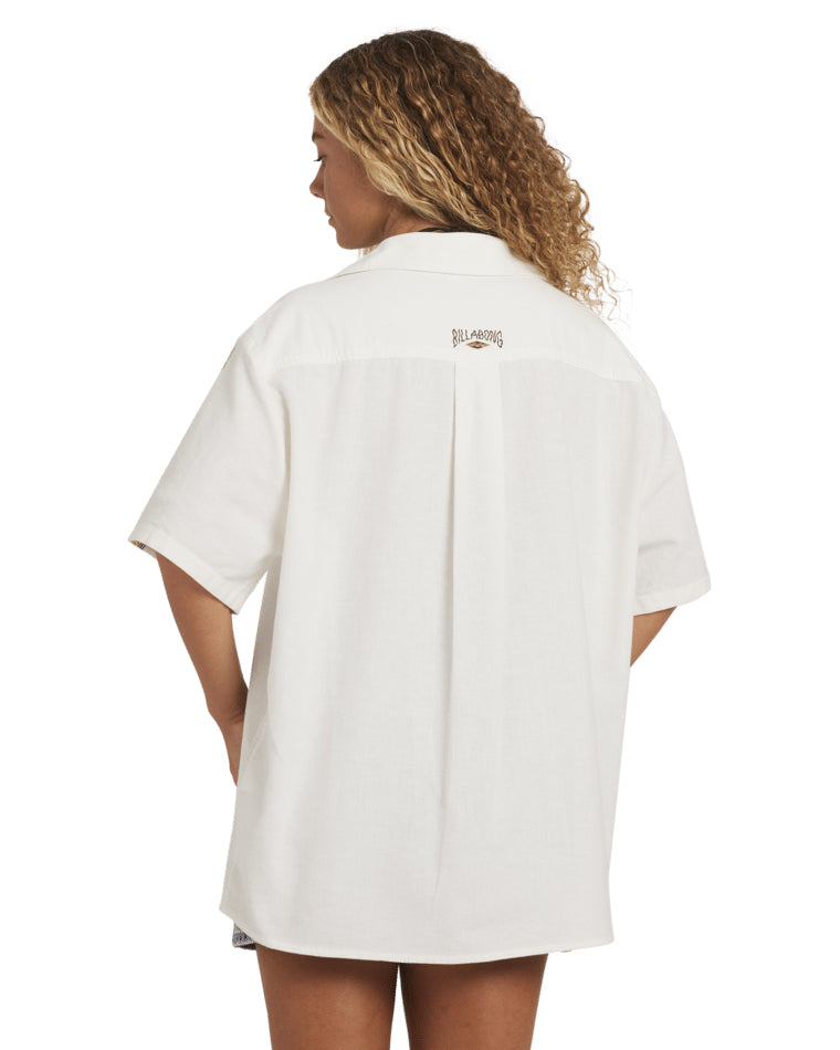 Back view of oversized white shirt with short sleeves and Billabong logo at upper back.