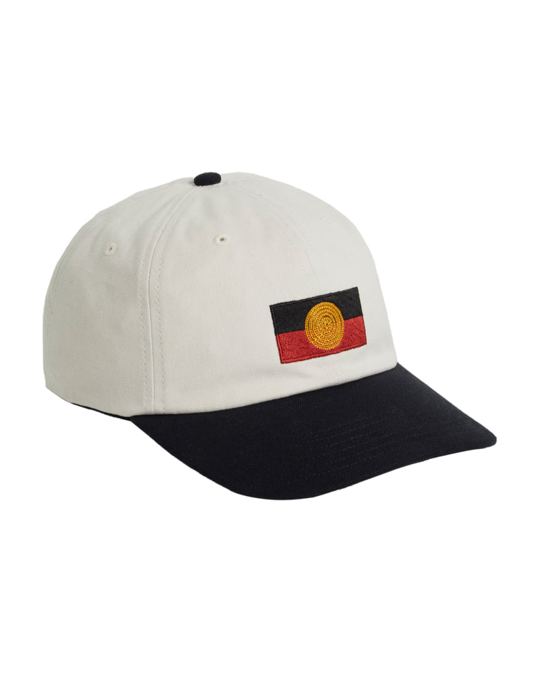 Opposite side angle of white cap with black brim and Aboriginal flag detail on the front.