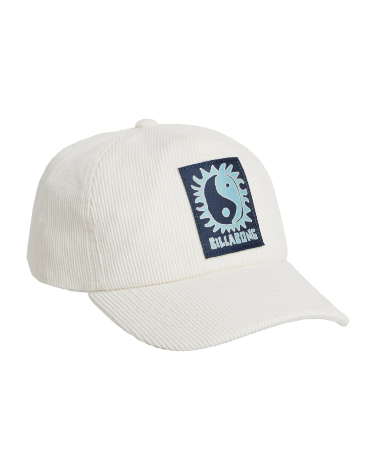 Angled view of cream corduroy cap featuring a square navy patch with a sun and yin-yang design and Billabong logo.