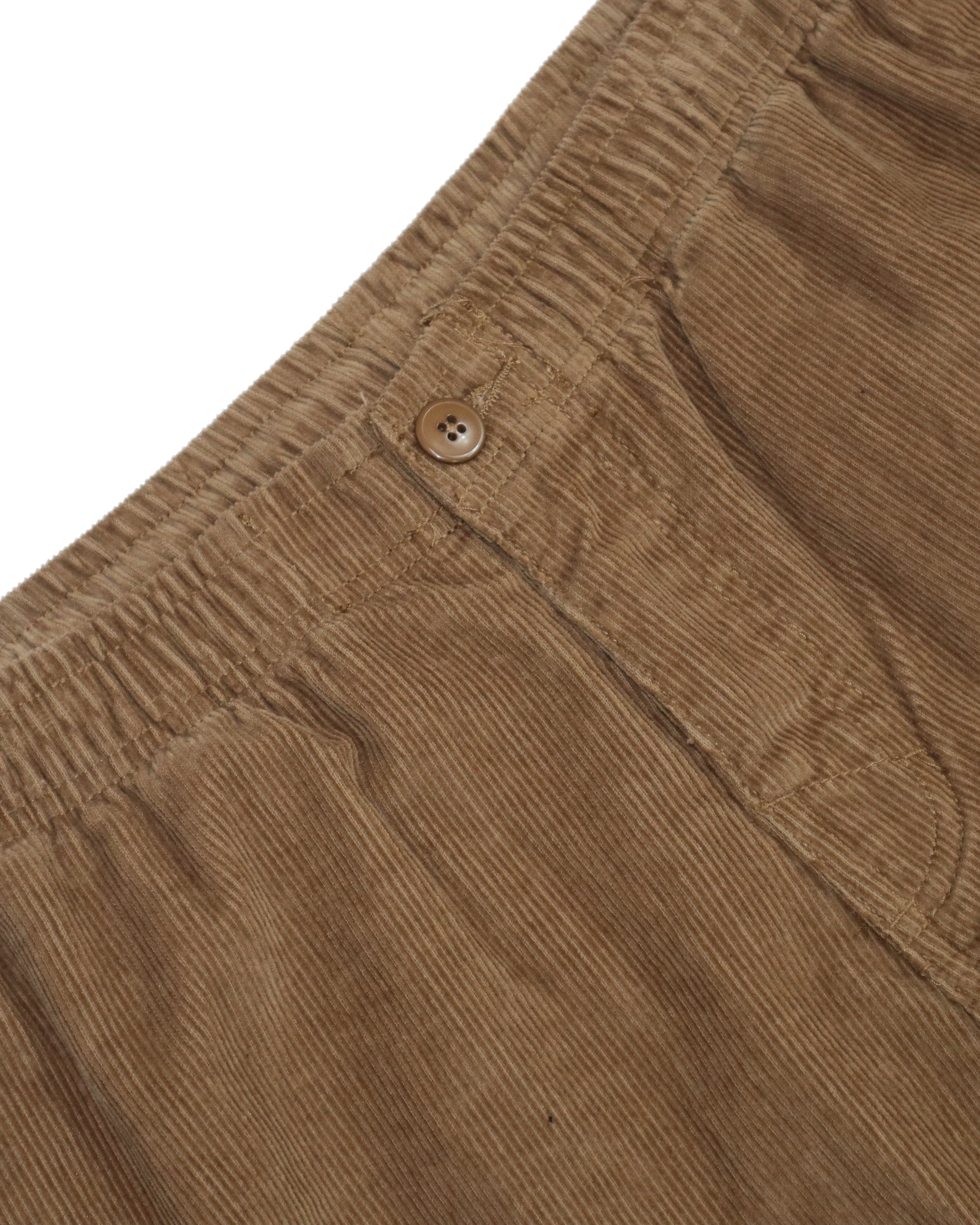 Close-up of brown corduroy fabric with button and waistband detail.