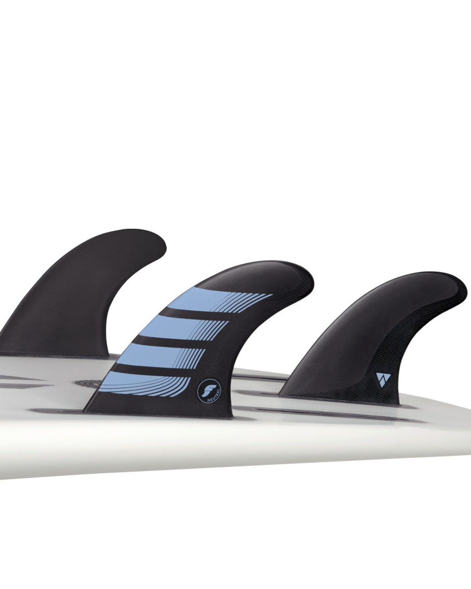 Futures Netplus thruster fin set installed on a white board, with eco-friendly black and blue design for balanced performance.