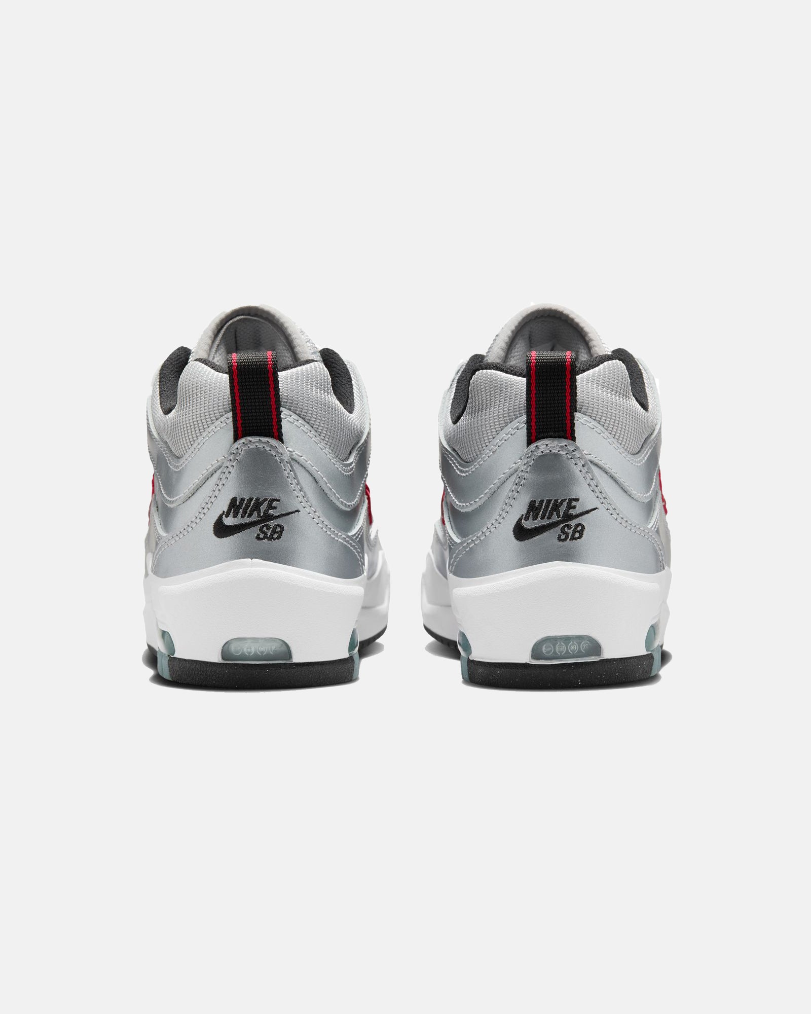 Rear view of silver Nike Air Max sneakers with black logo branding, red pull tabs, white midsoles, and black outsoles.