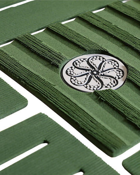 Close-up of green traction grooves and embossed circular logo detail.
