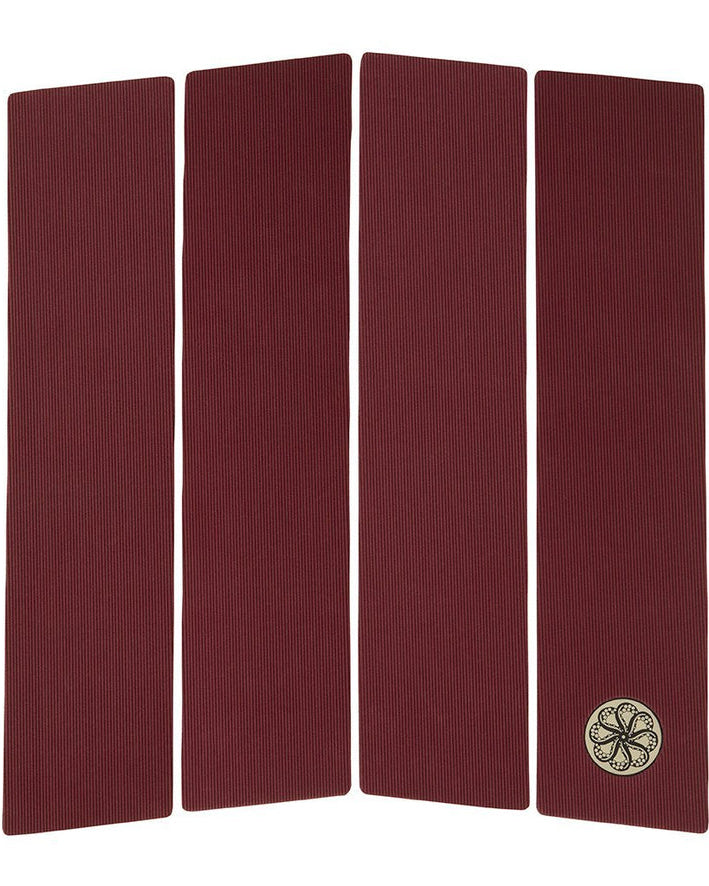 Maroon four-piece flat deck traction pad with fine ribbed texture and circular logo.