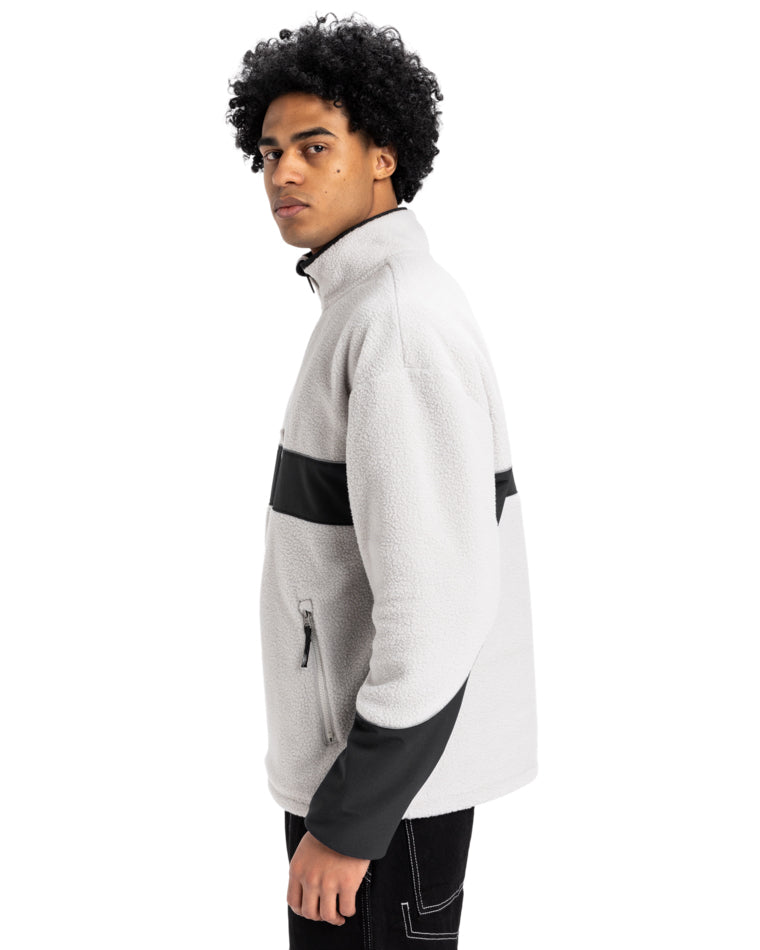 Side view of men's light grey and black Quiksilver fleece pullover with contrast panel, zip pockets, and high collar.