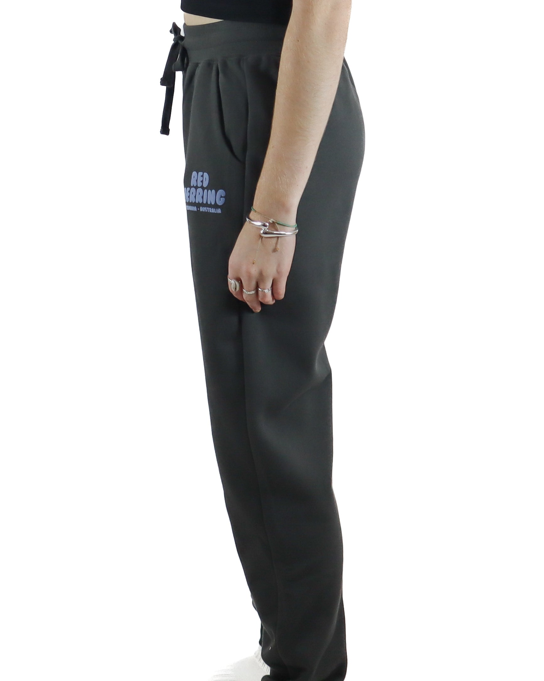 Side view of black jogger pants showing relaxed fit and Red Herring logo on the front.