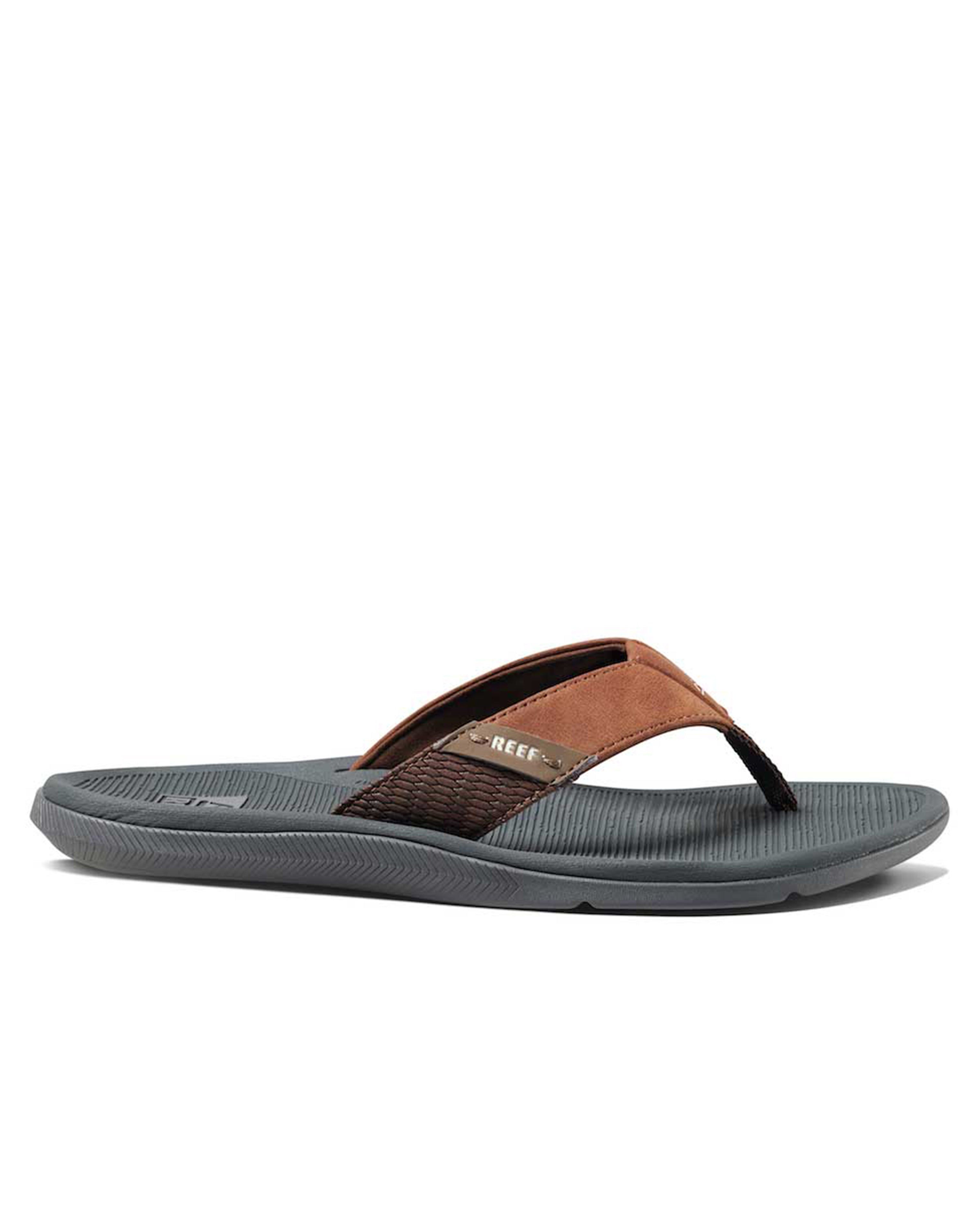 Reef thong sandal with brown leather strap and grey cushioned footbed.