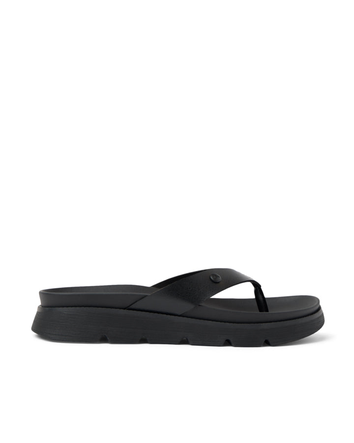 Side view of black platform thong sandals with textured sole and wide straps