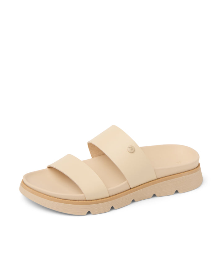 Angled view of a beige slide sandal featuring two wide straps and a cushioned sole.