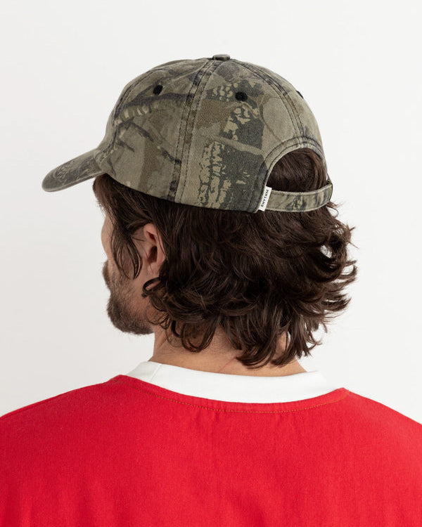 Back view of camo Rhythm cap worn with red tee, showing strap and fit