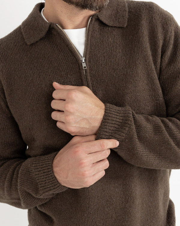 Close-up of brown knit jumper sleeve and zip collar detail