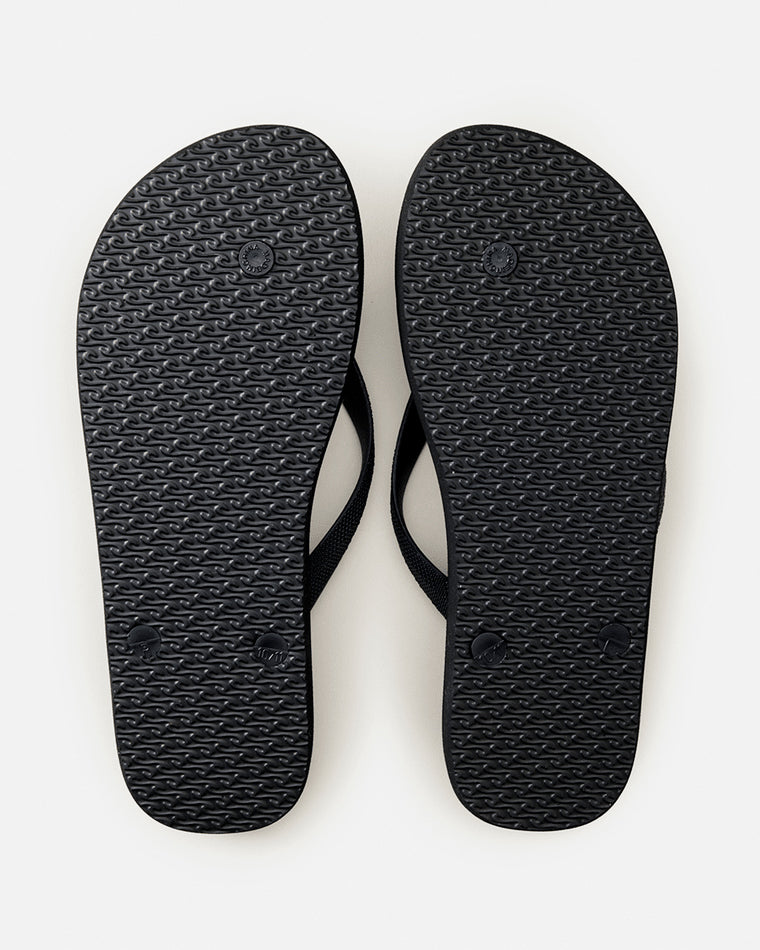 Underside of Rip Curl thongs with textured black sole and circular grip pattern