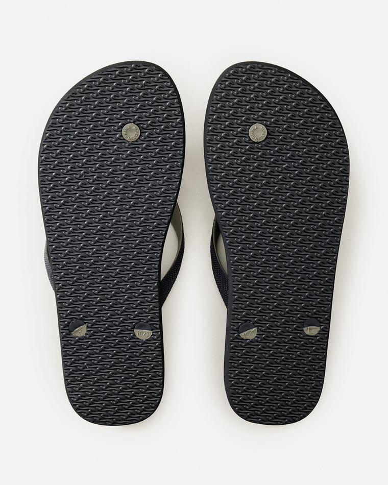Underside of Rip Curl thongs with black textured soles and visible plug attachments.