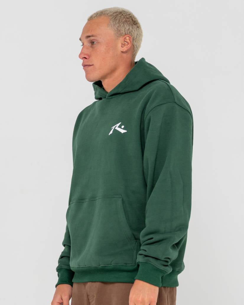 Side view of a model wearing a forest green hoodie with a white logo on the chest, featuring a relaxed fit and front pocket.