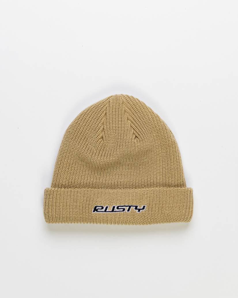 Beige knitted beanie with a folded cuff, featuring the 'Rusty' logo embroidered in black and white on the front.