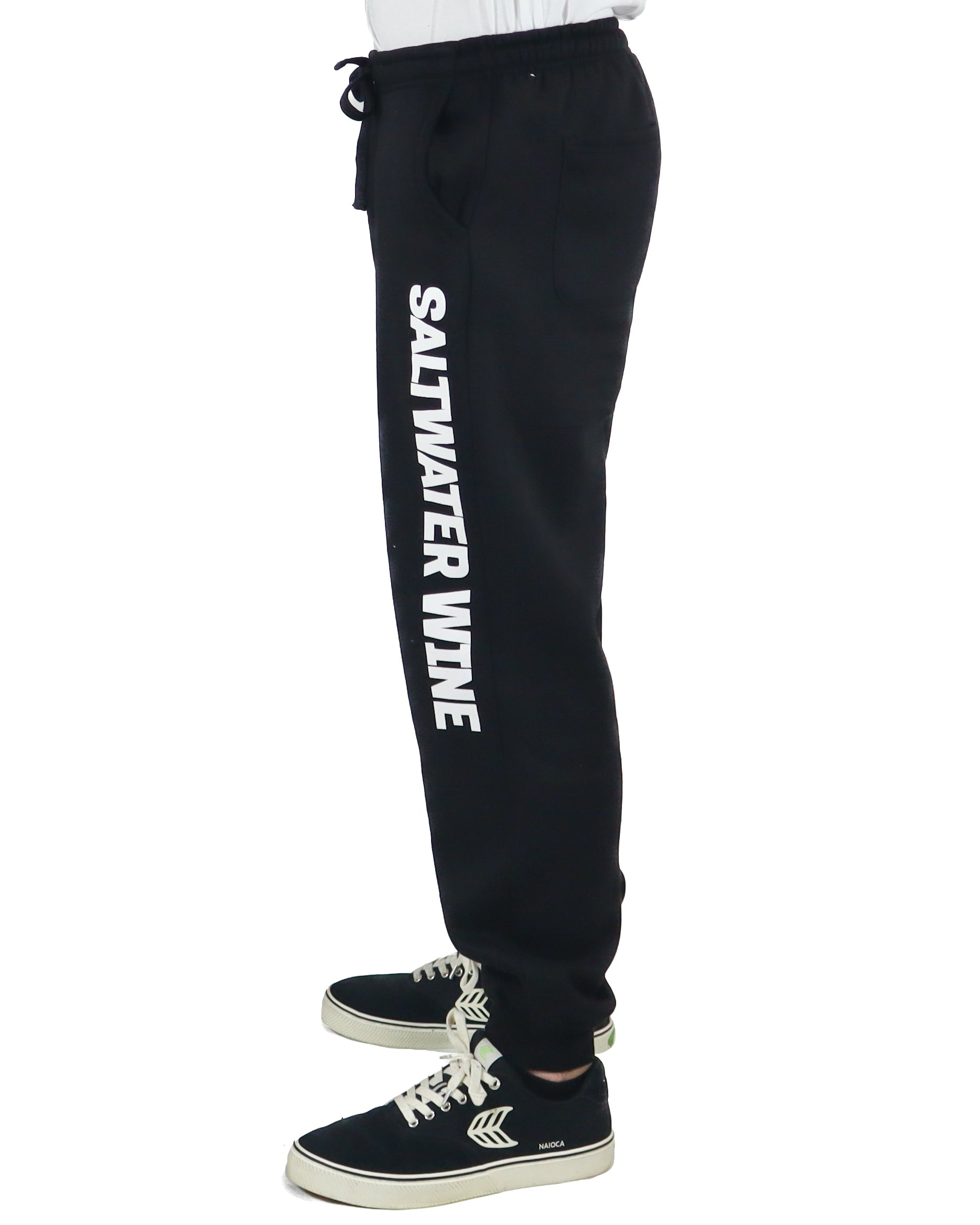 Side view of black joggers with bold SALTWATER WINE text on leg