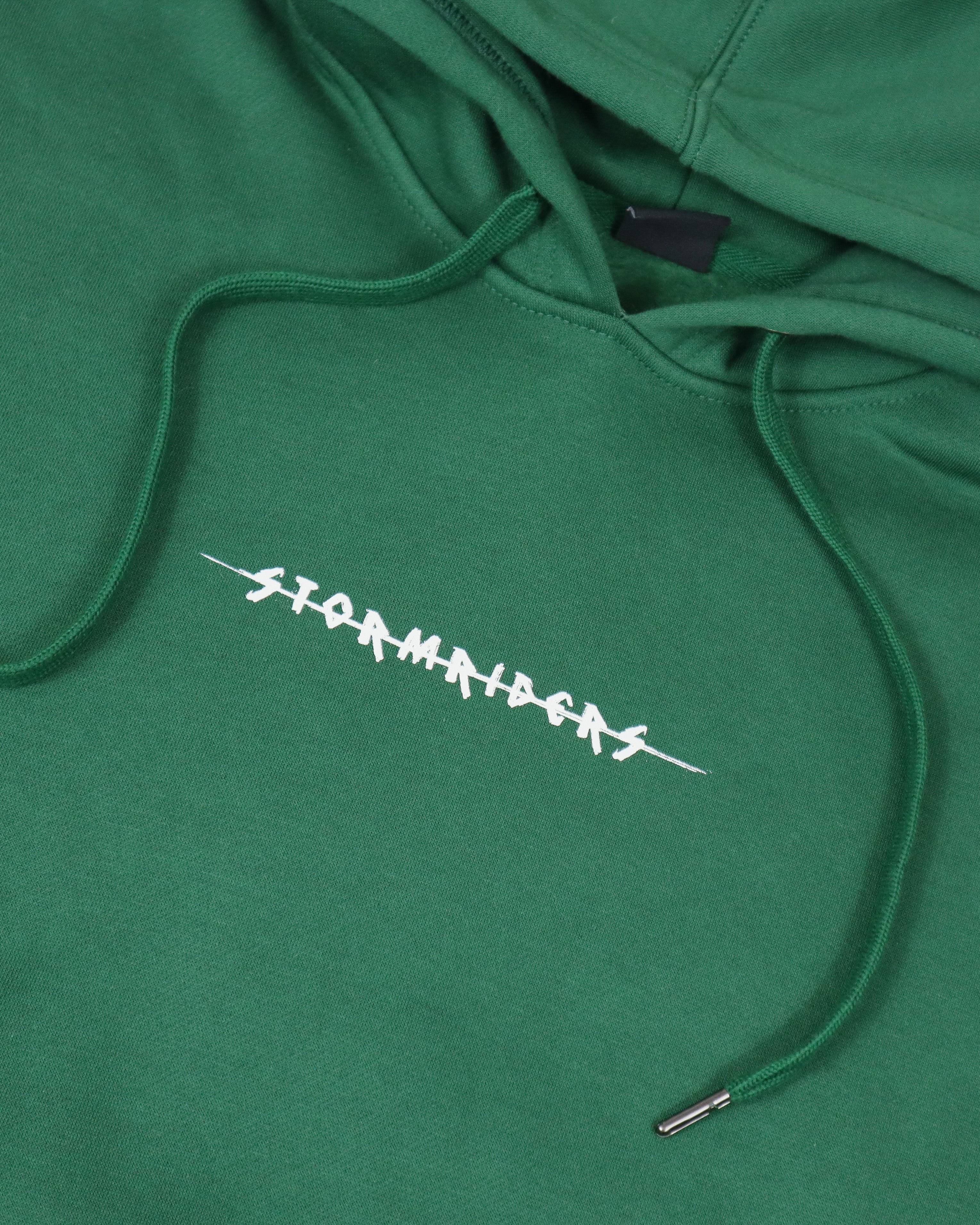 Close-up of embroidered Stormriders logo on green hoodie fabric