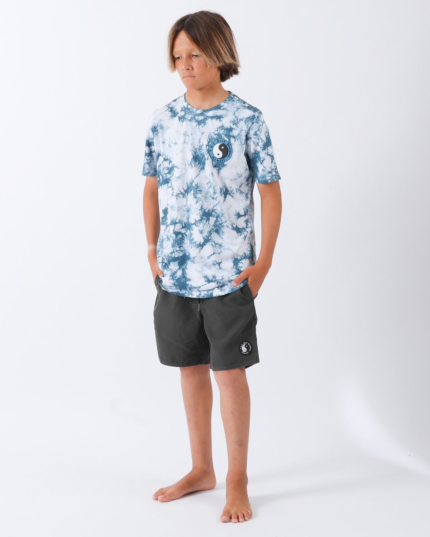 Blue and white tie-dye T-shirt with small yin-yang T&C Surf Designs Hawaii chest print, styled with dark shorts.