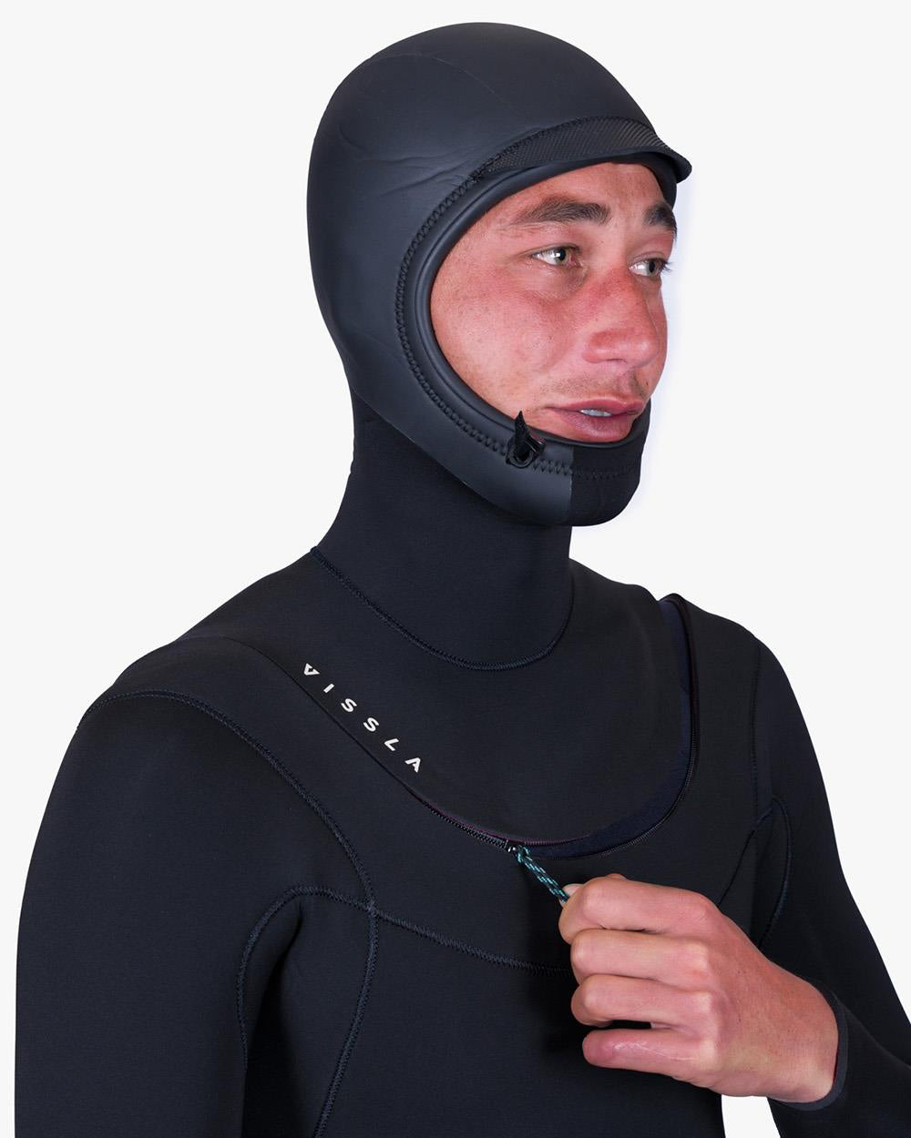 Man in a wetsuit with a hood, adjusting the zipper on the neck area, showcasing the Vissla logo on the chest.