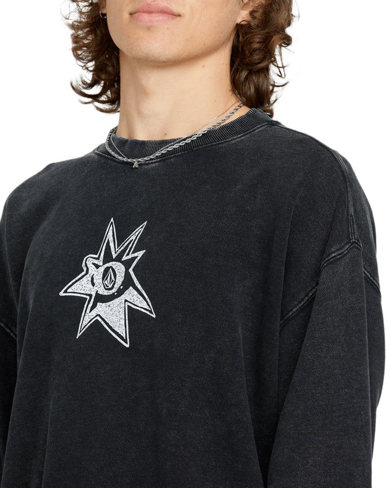 Close-up of a black vintage-wash Volcom crewneck sweatshirt featuring a distressed graphic logo on the chest.