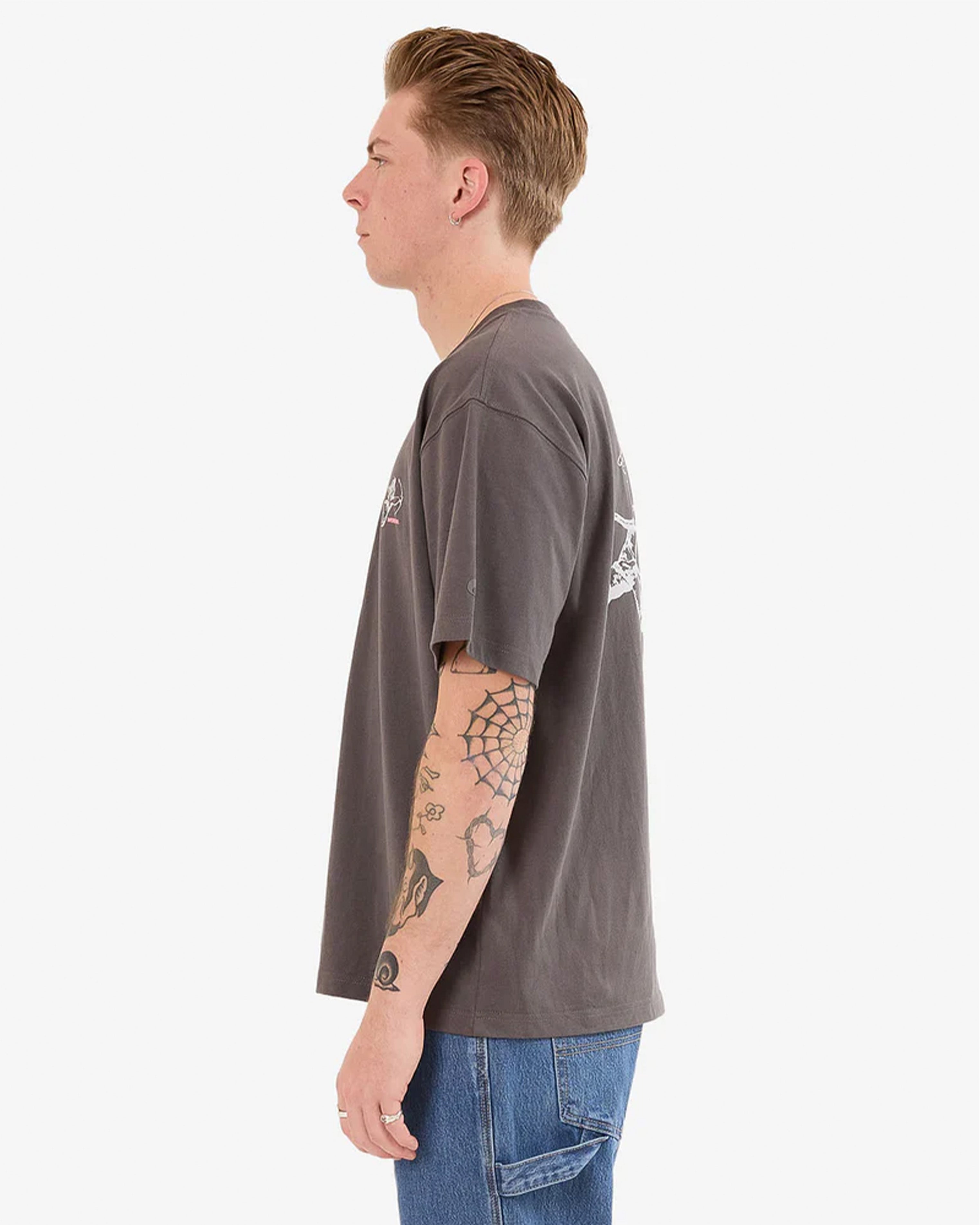 Side view of a dark grey t-shirt worn with blue jeans, featuring a relaxed fit and dropped shoulders.