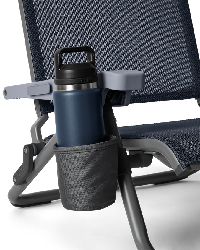 Close-up of Yeti navy beach chair cup holder with bottle inside.