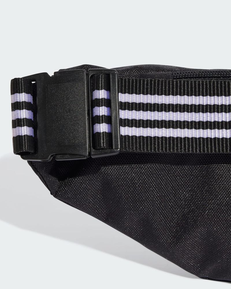 Adjustable strap with black and white stripes and buckle on adidas waist bag.