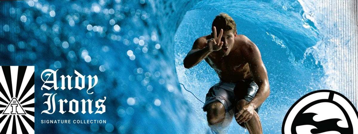 Andy Irons crouches inside a blue ocean wave, making a peace sign. Large text on the left reads 'Andy Irons' with 'Signature Collection' below, and a circular logo appears in the lower right.