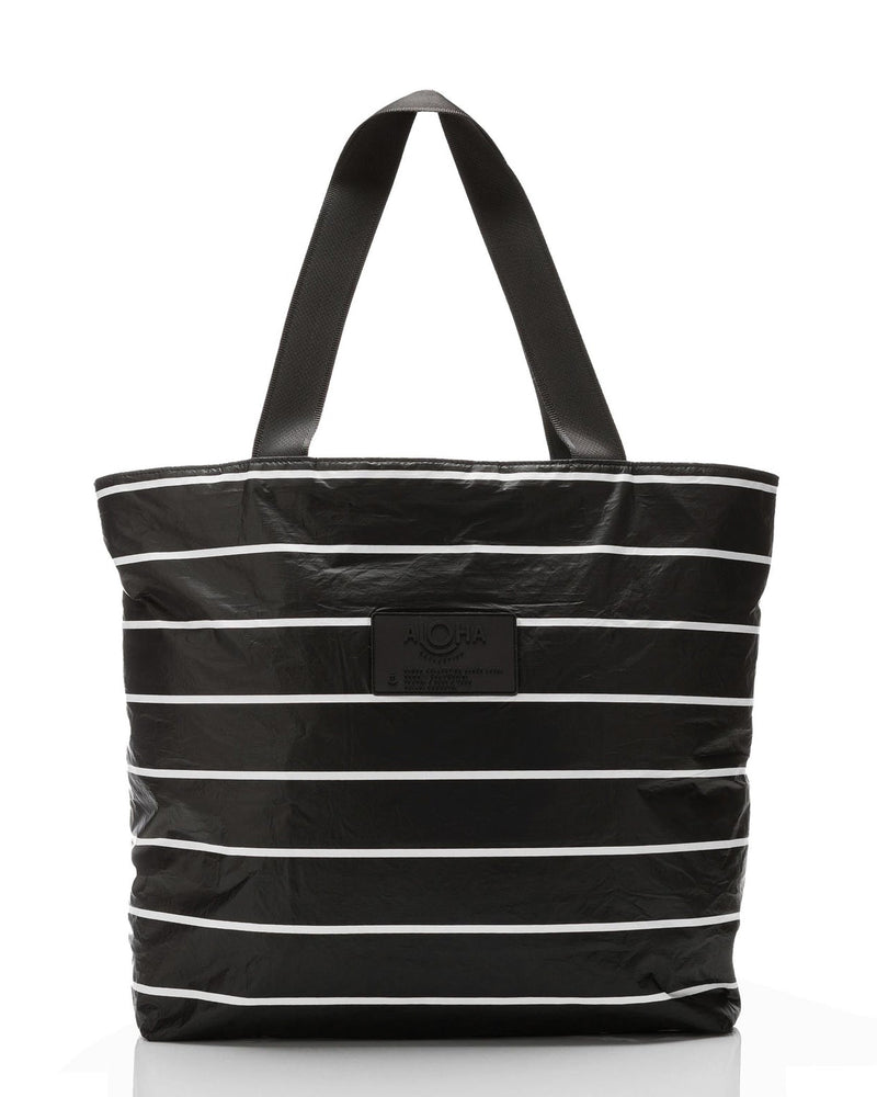 Black tote bag with white horizontal stripes and dual handles, featuring front logo patch