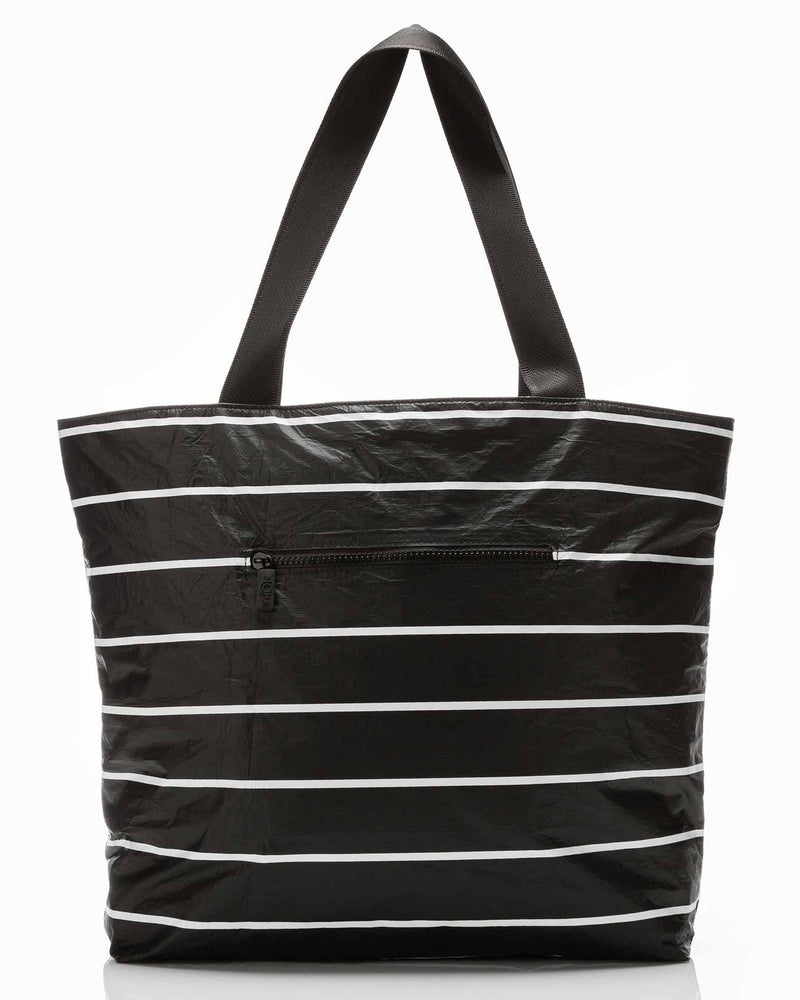 Rear view of black striped tote bag with zippered outer pocket and shoulder straps
