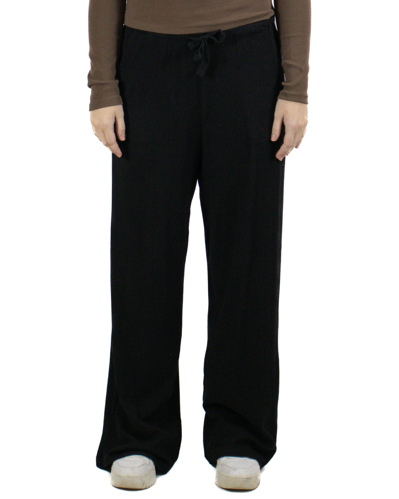 Woman wearing black ribbed wide-leg pants with drawstring waist and white sneakers
