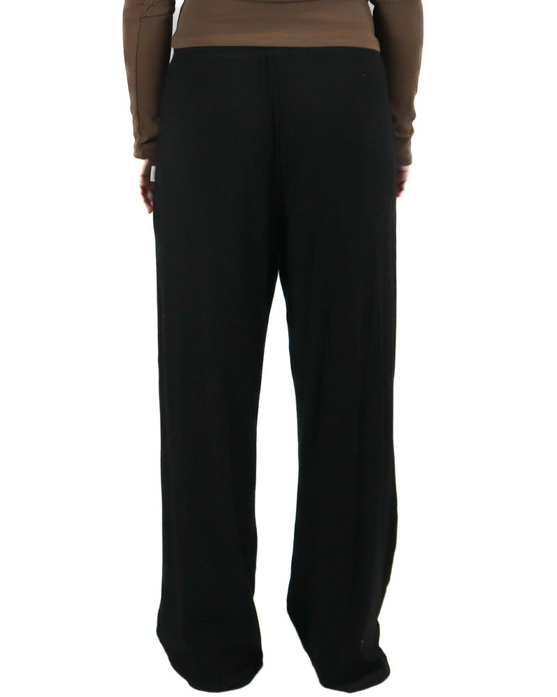 Rear view of black ribbed lounge pants with a relaxed fit and high waist