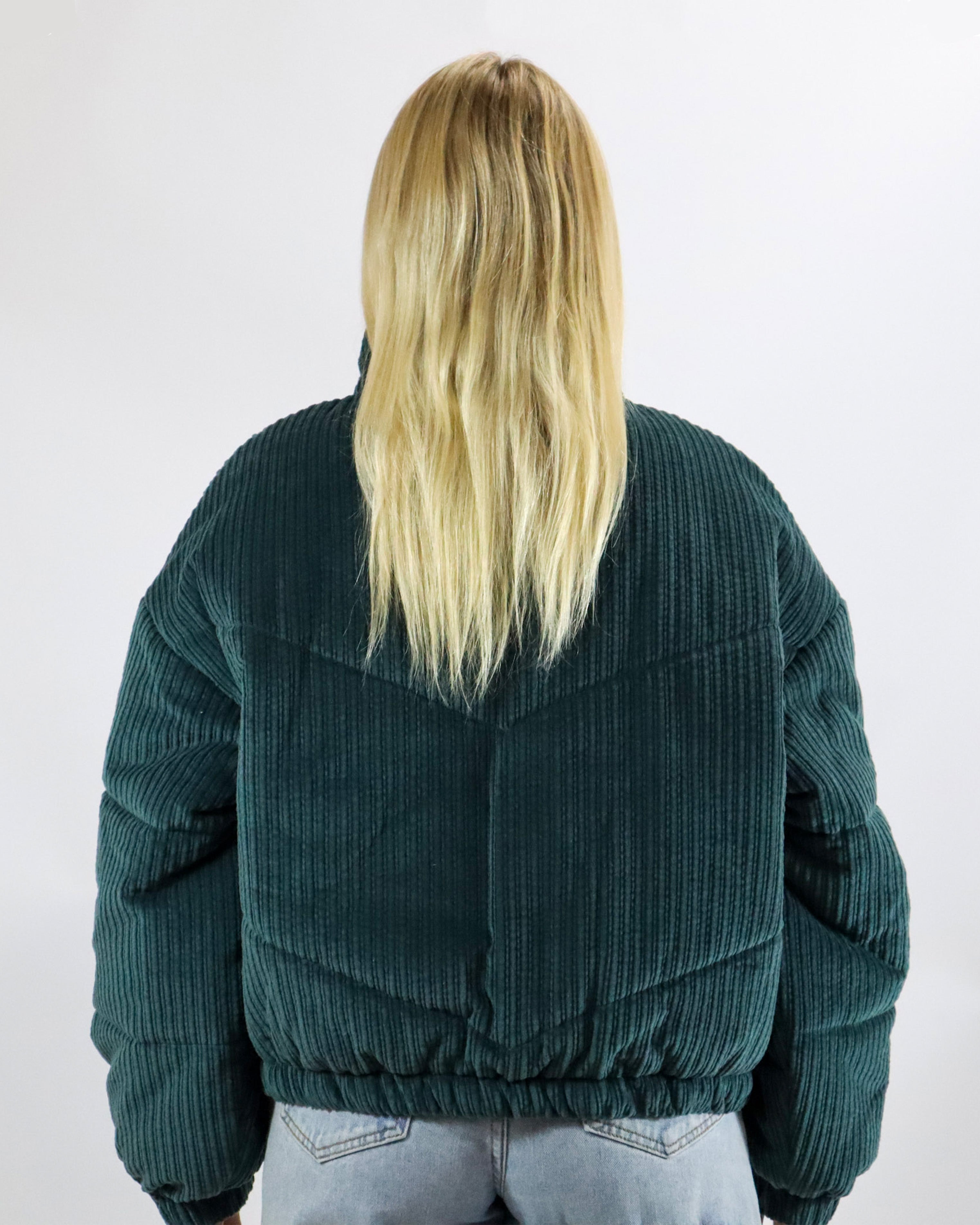 Back view of dark green cord puffer jacket with chevron panel design