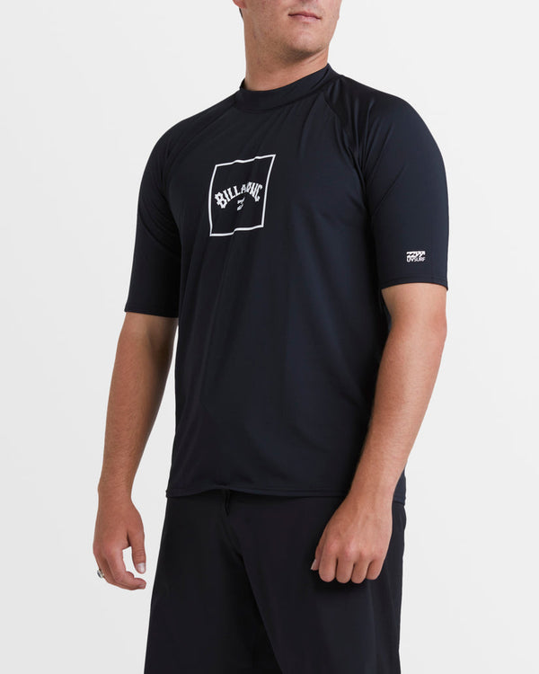 Black Billabong rash vest with white logo graphic on chest and snug fit short sleeves