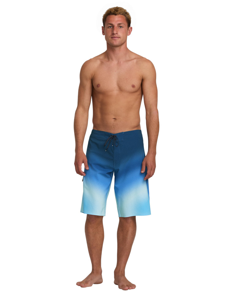 Model wearing ombre blue boardshorts with fade detail and knee-length cut