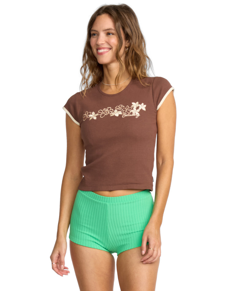 Brown cap sleeve tee with floral embroidery and green ribbed shorts.