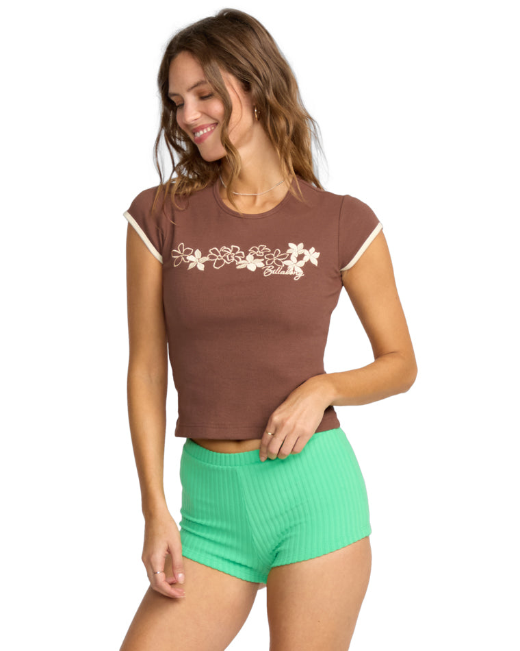 Angled view of a brown floral tee paired with green ribbed fitted shorts.