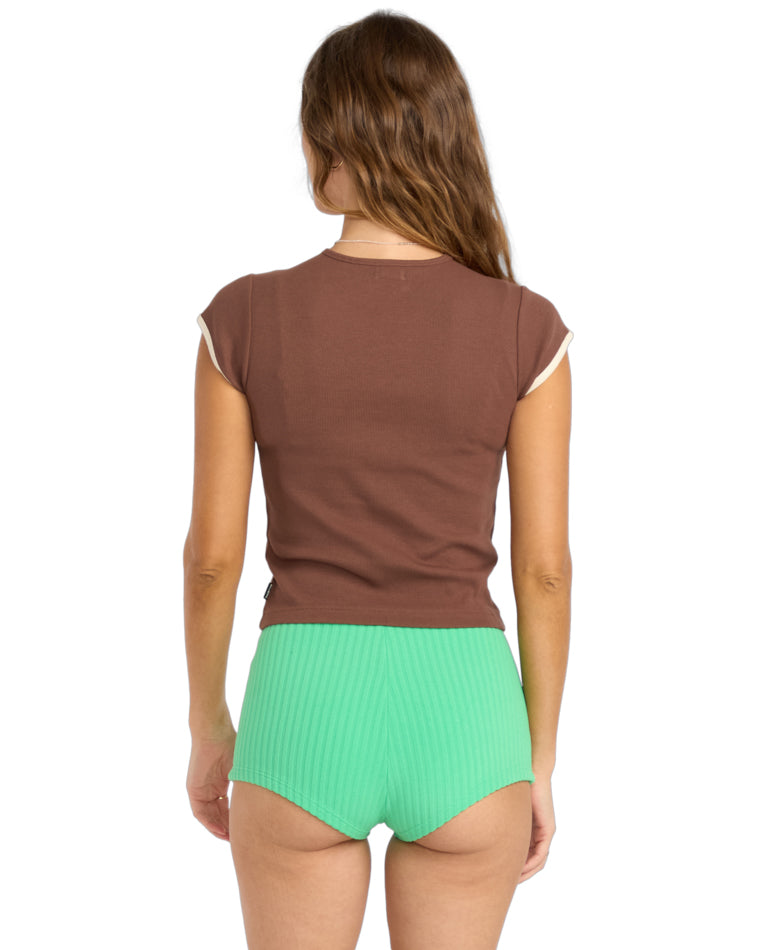 Back view of brown tee with cream trim and green ribbed shorts.