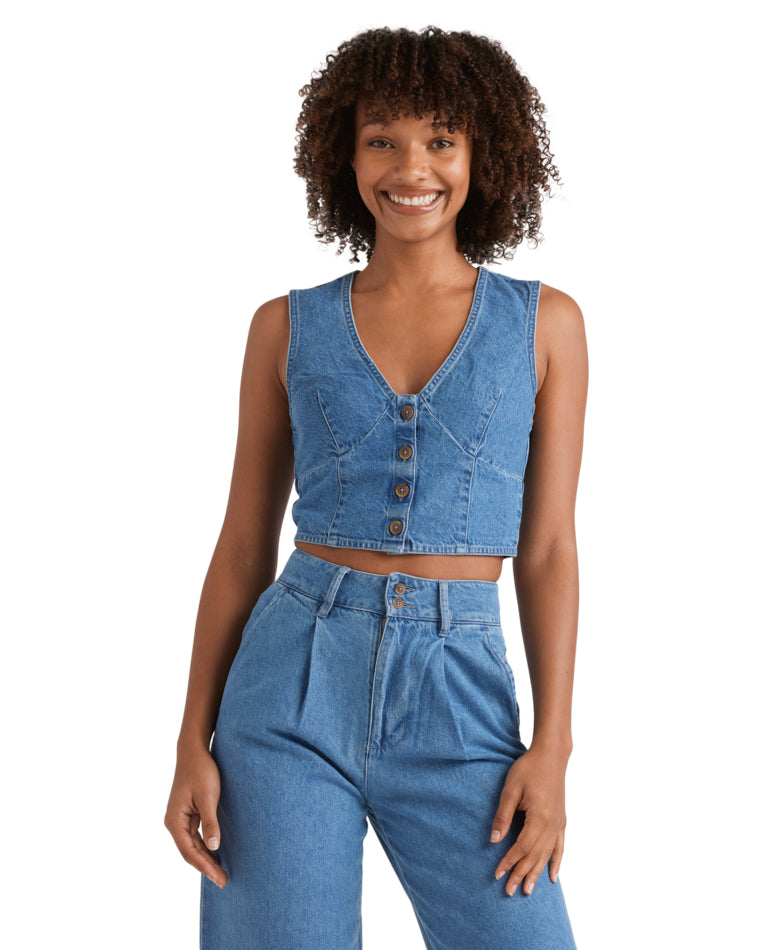 Denim crop vest with button-up front and deep V-neckline, styled with matching high-waisted jeans.