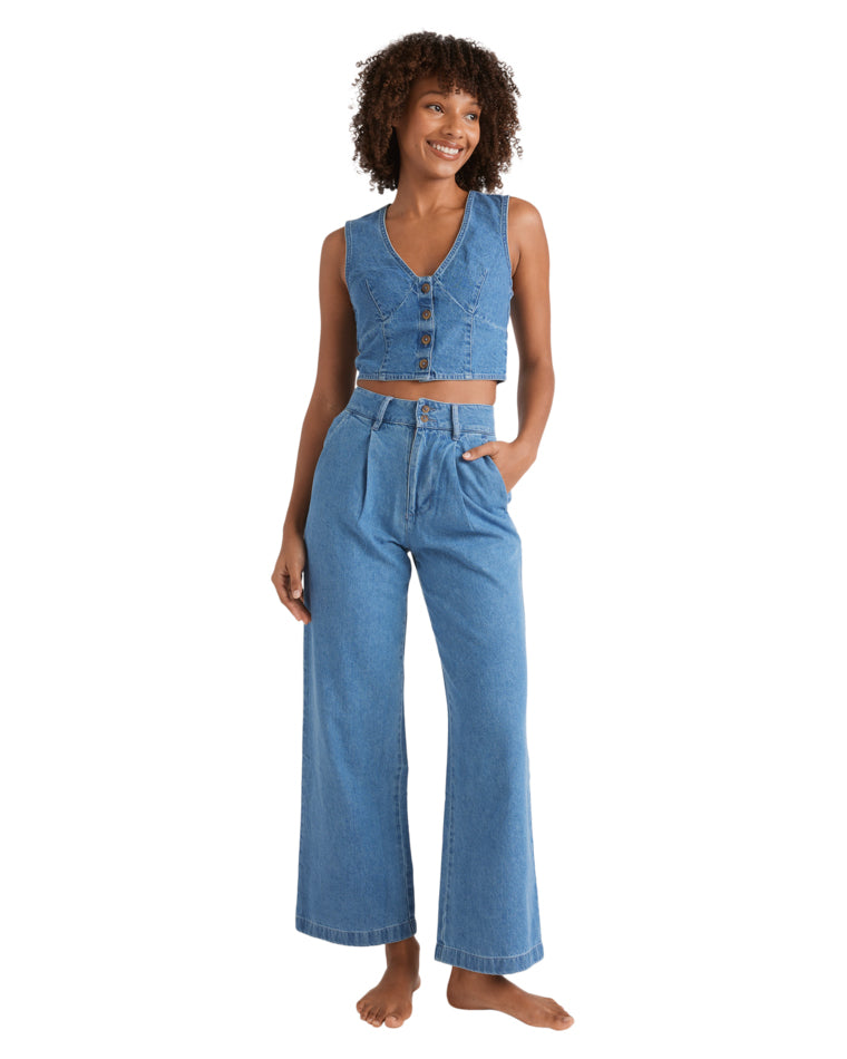 Full body view of matching sleeveless denim vest and high-waisted wide-leg jeans set.