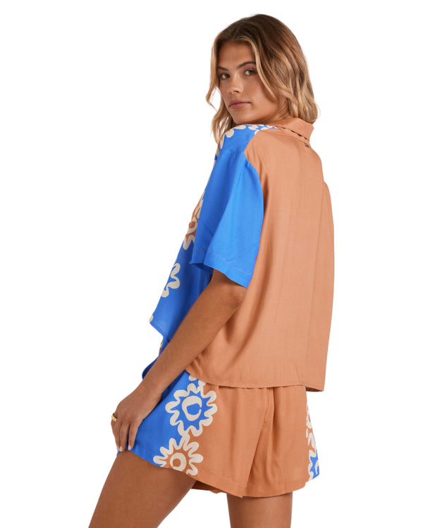 Back view of a brown and blue short-sleeve shirt with floral detailing.
