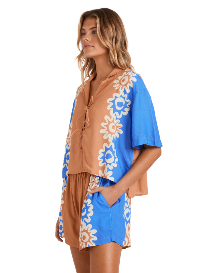 Side view of a brown and blue floral short-sleeve shirt with front ties.