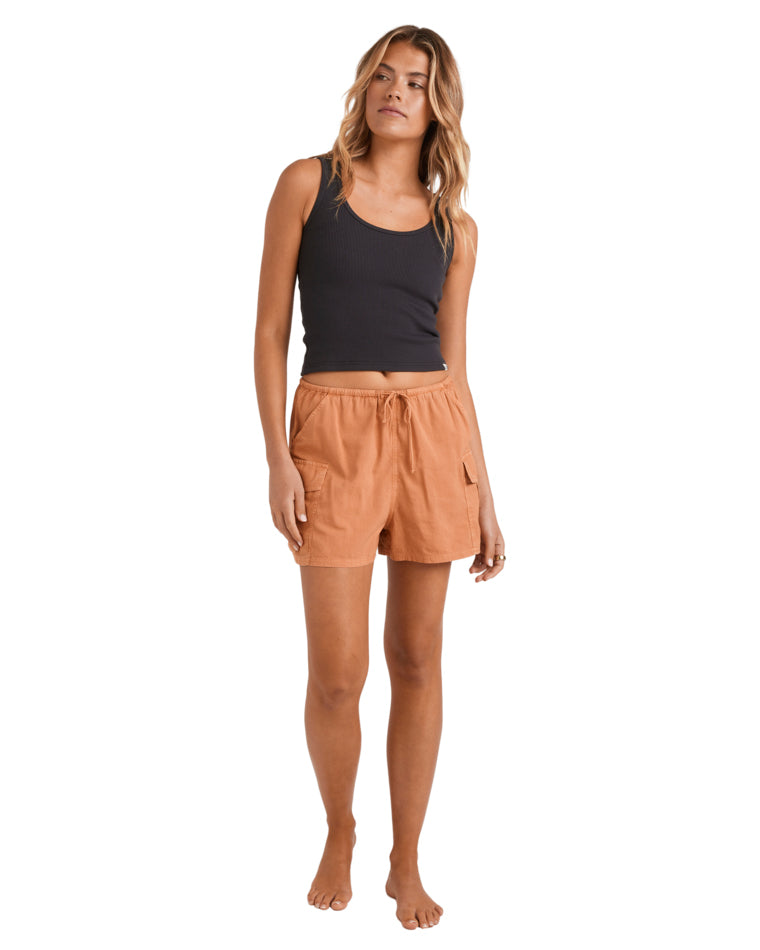 Full-body view of black ribbed tank and rust shorts styled casually