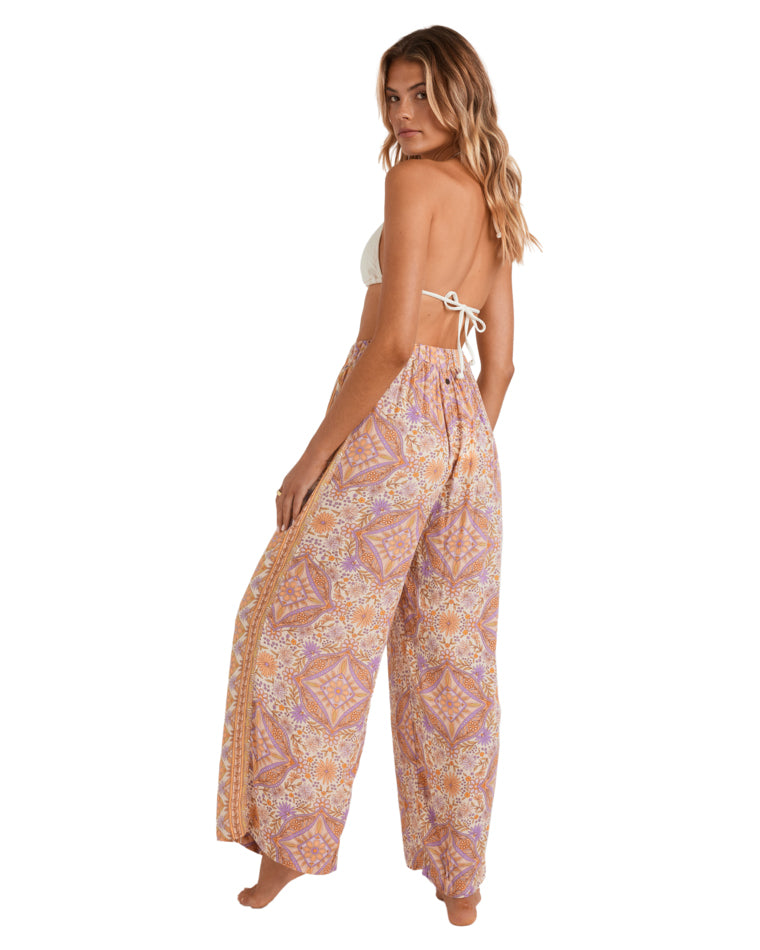 Back view of printed wide-leg pants with orange, purple, and white pattern