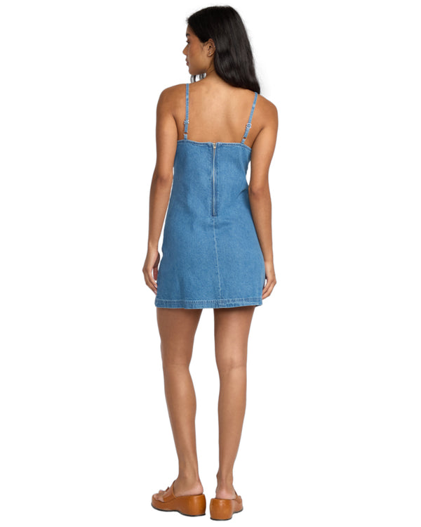 Back view of the denim mini dress showing a zip closure and adjustable straps.