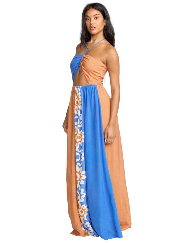 Angled view of a halterneck cut-out maxi dress featuring a floral printed panel on a tan and blue base.